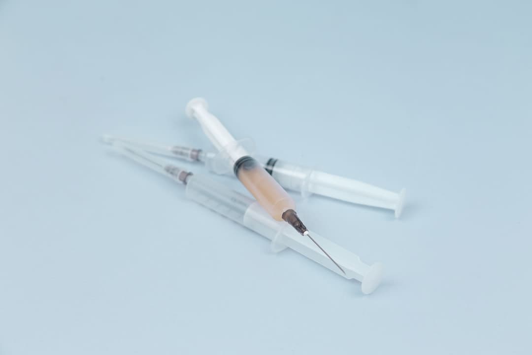Two prefilled medical syringes on a white surface